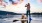 woman and her dog on stand up paddle board on lake