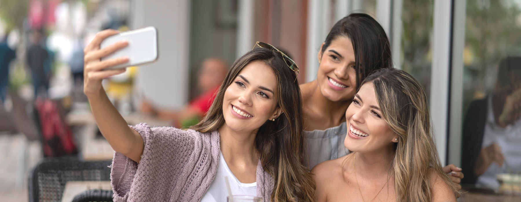 group of girlfriends take a selfie in front of an local restaurant